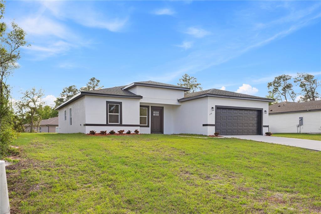 a view of a house with a yard and a garage