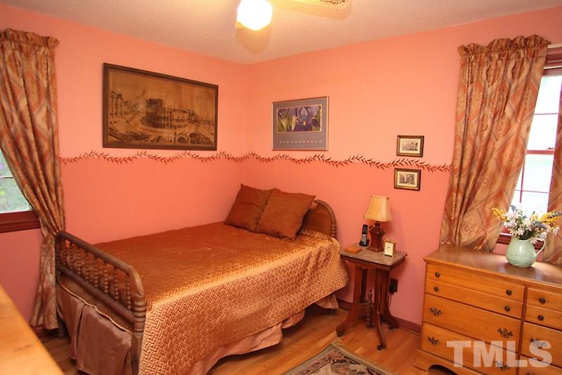 4616 Waterbury Road Raleigh, NC 27604 - Photo 8 of 12 a bedroom with a bed and wooden floor