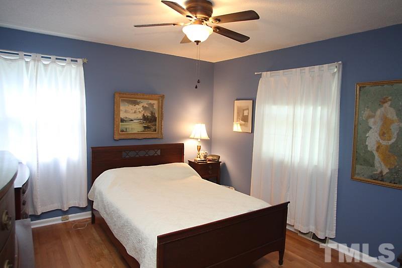 4616 Waterbury Road Raleigh, NC 27604 - Photo 9 of 12 a bedroom with a bed and a chandelier