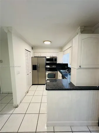 a kitchen with stainless steel appliances granite countertop a refrigerator and a stove