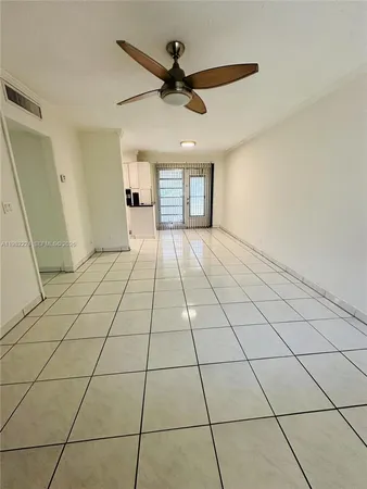 a view of an empty room and a ceiling fan