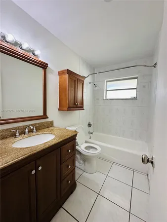 a bathroom with a double vanity sink a toilet a mirror and shower