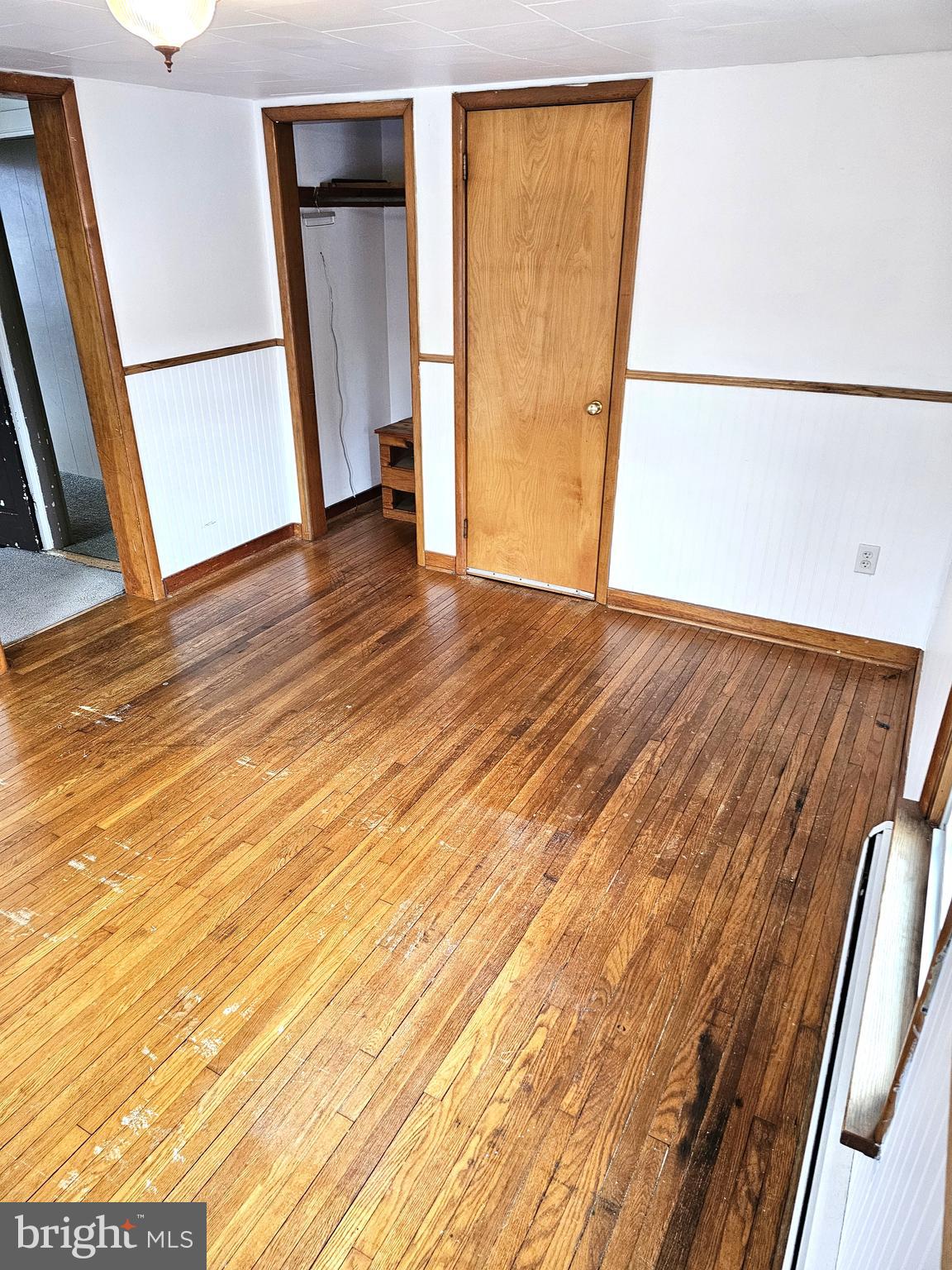 75 King Street Milroy, PA 17063 - Photo 5 of 19 an empty room with wooden floor and door