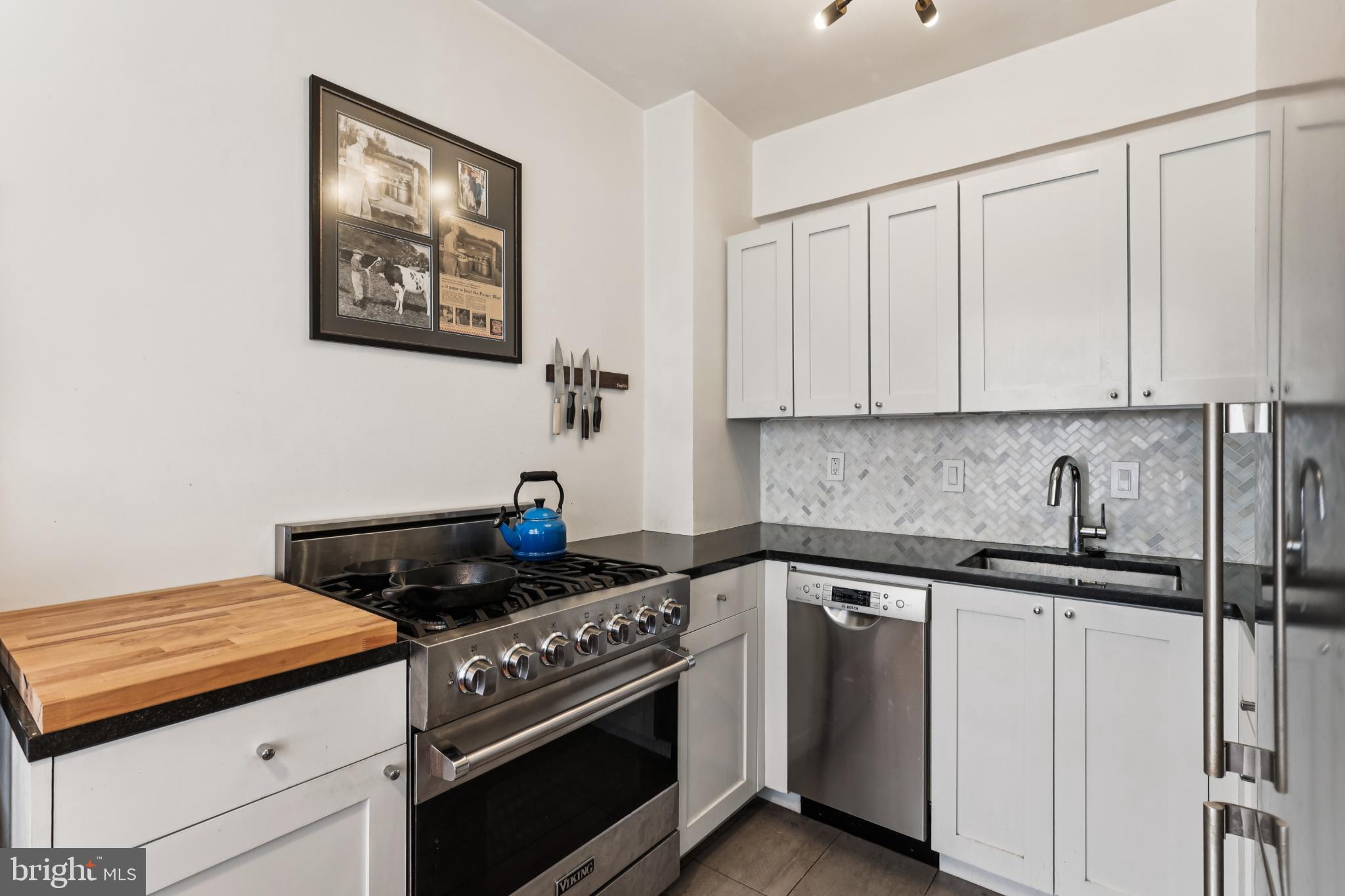 1365 Kennedy Street Northwest, Unit 209 Washington, DC 20011 - Photo 1 of 35 a kitchen with stainless steel appliances granite countertop white cabinets and a stove top oven