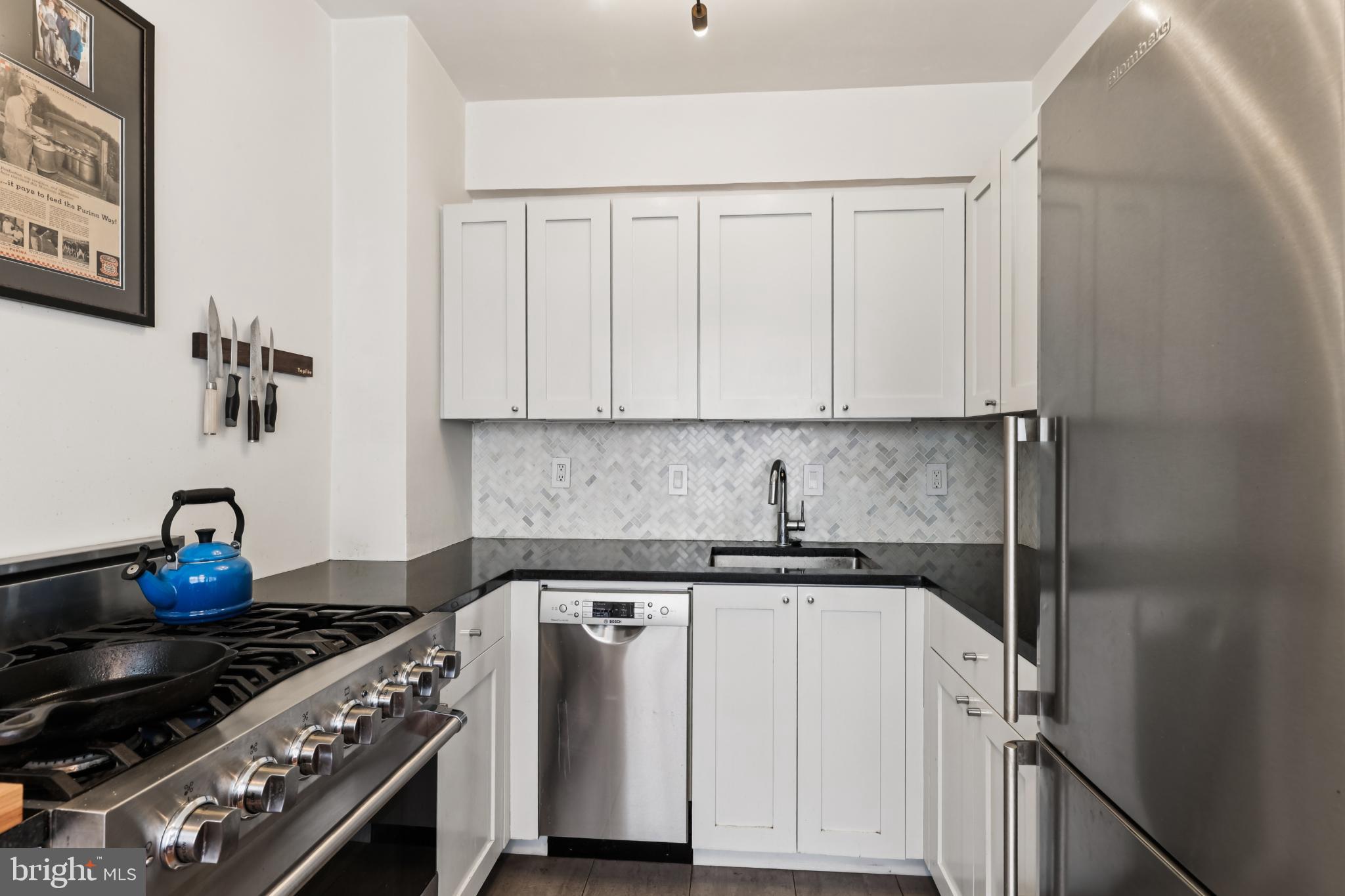 1365 Kennedy Street Northwest, Unit 209 Washington, DC 20011 - Photo 13 of 35 a kitchen with a stove and white cabinets