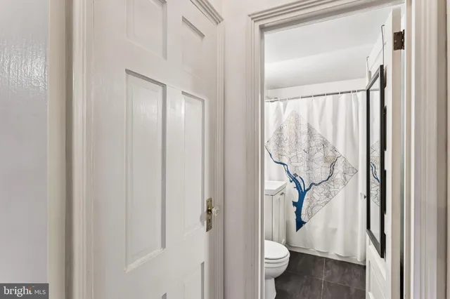 a bathroom with a granite countertop sink and a toilet