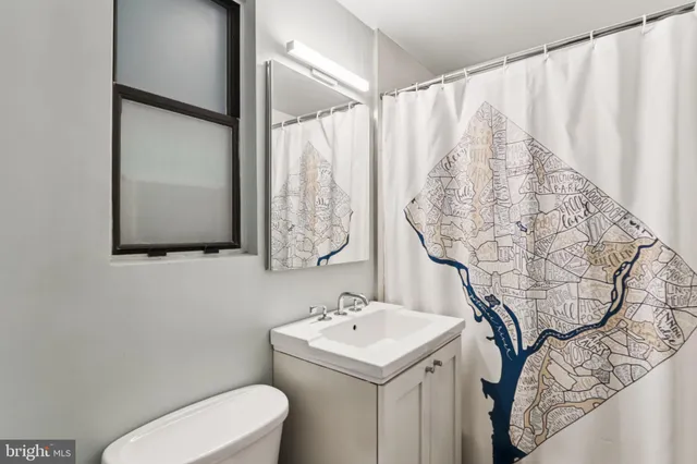 a bathroom with a sink and mirror with toilet
