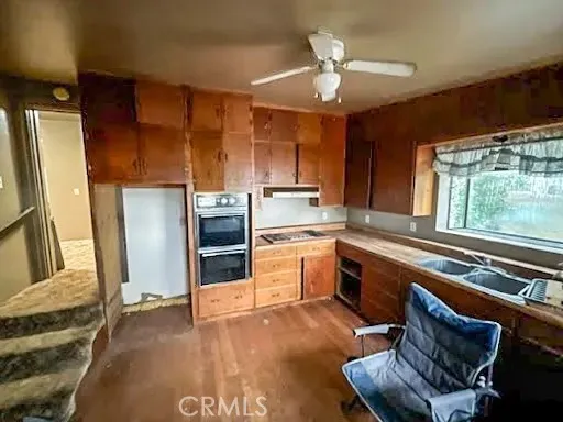 a kitchen with a sink appliances cabinets and a counter top space
