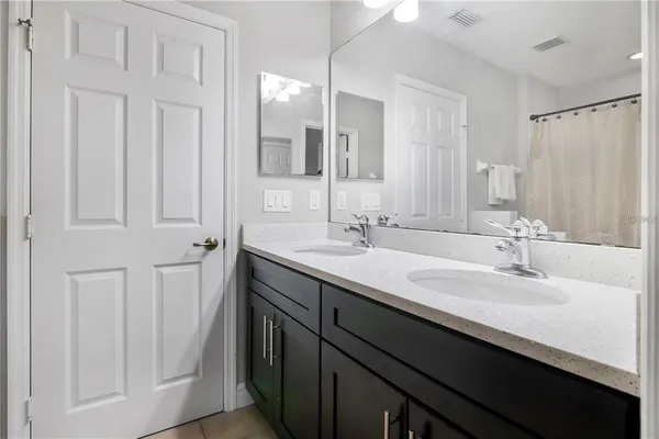 a bathroom with a double vanity sink and a mirror