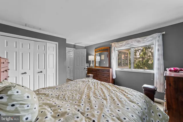 a bedroom with a bed and a dresser next to a window