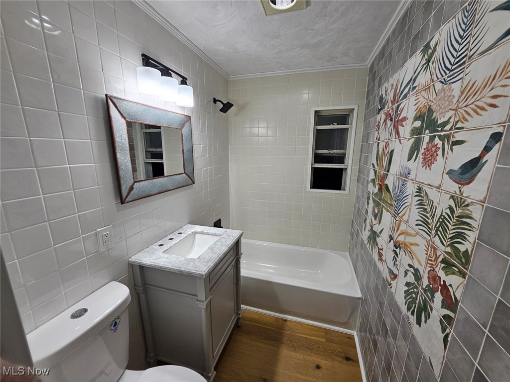 3999 Lancaster Road South Euclid, OH 44121 - Photo 7 of 17 Full bathroom featuring toilet, tile walls, tiled shower / bath combo, hardwood / wood-style flooring, and vanity
