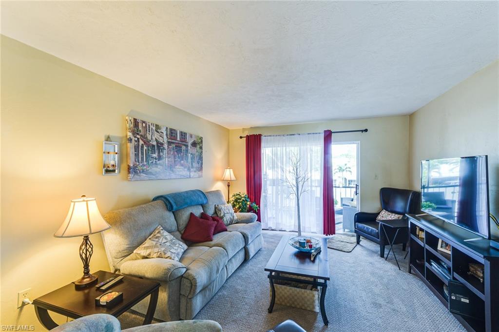 2100 Barkeley Lane, Unit 13 Fort Myers, FL 33907 - Photo 11 of 12 a living room with furniture and a flat screen tv