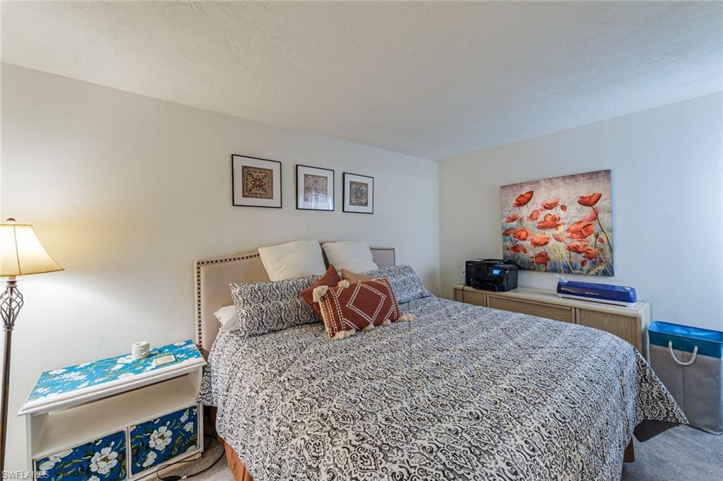 2100 Barkeley Lane, Unit 13 Fort Myers, FL 33907 - Photo 7 of 12 a bedroom with a bed and painting on the wall
