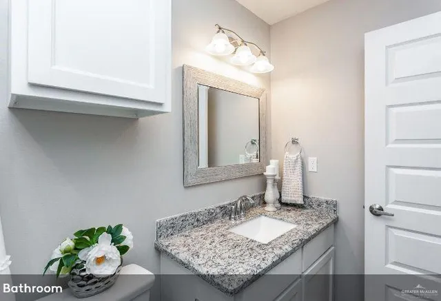 a bathroom with a granite countertop sink and a mirror