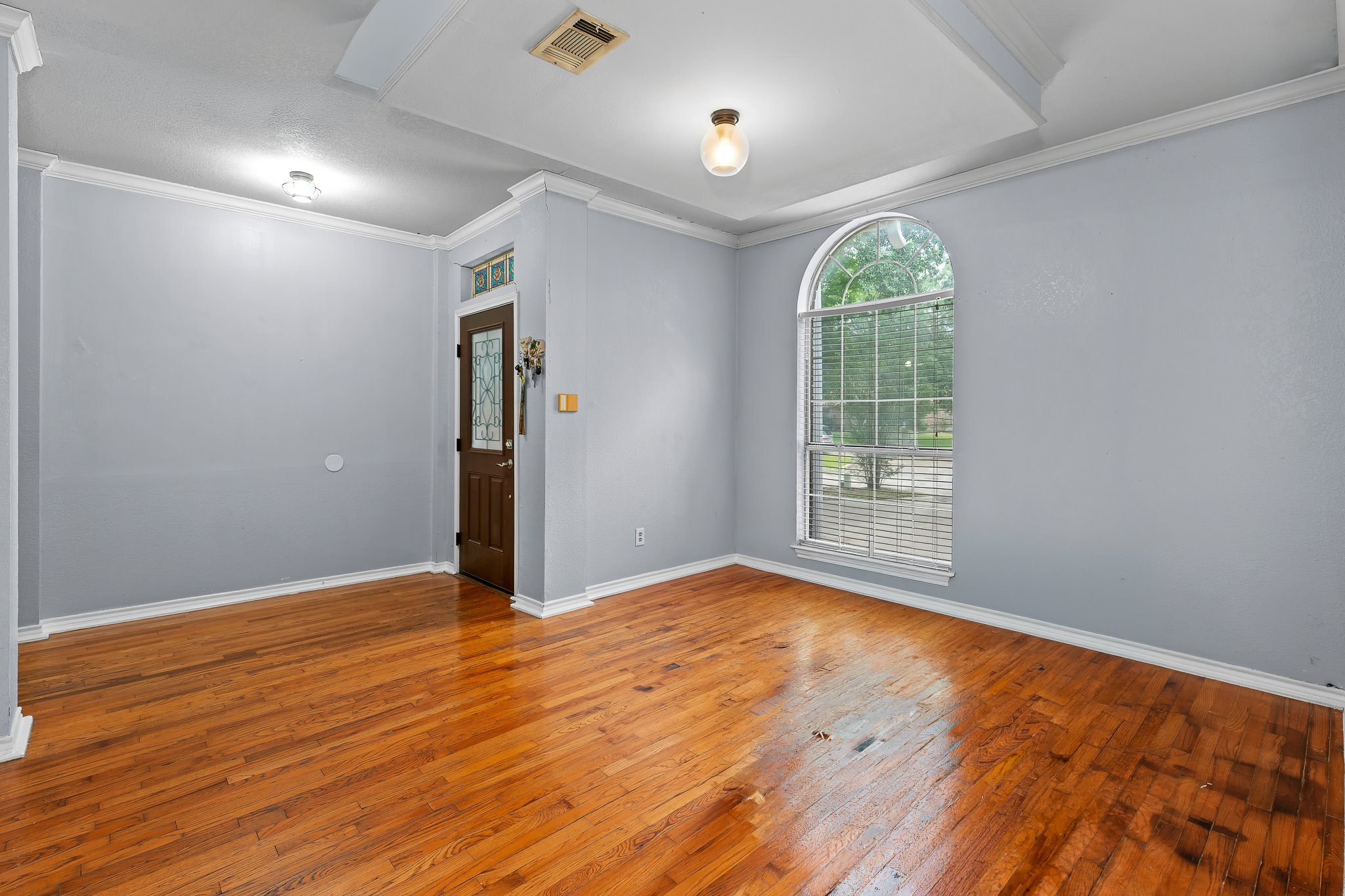 11737 Rydalwater Lane Austin, TX 78754 - Photo 7 of 40 Refinished wood-finish flooring complements the tray ceiling and crown molding