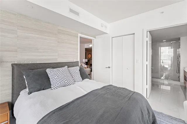 a bedroom with a large bed and wooden floor