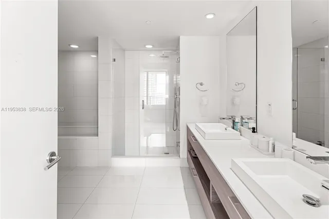 a bathroom with a double vanity sink mirror double and shower
