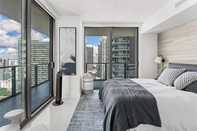 a spacious bedroom with a bed and glass door
