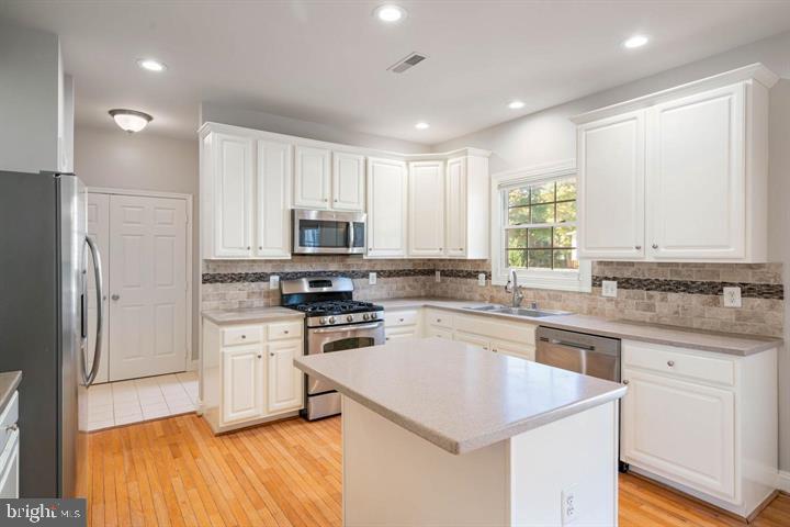 2038 Madrillon Road Vienna, VA 22182 - Photo 12 of 63 a kitchen with white cabinets appliances and sink