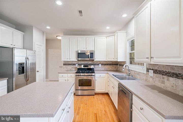 2038 Madrillon Road Vienna, VA 22182 - Photo 13 of 63 a kitchen with a sink a counter top space stainless steel appliances and cabinets