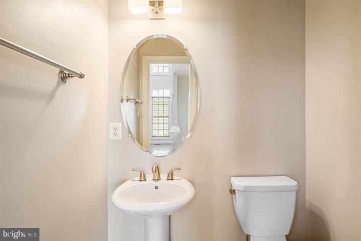 2038 Madrillon Road Vienna, VA 22182 - Photo 29 of 63 a bathroom with a toilet sink and mirror