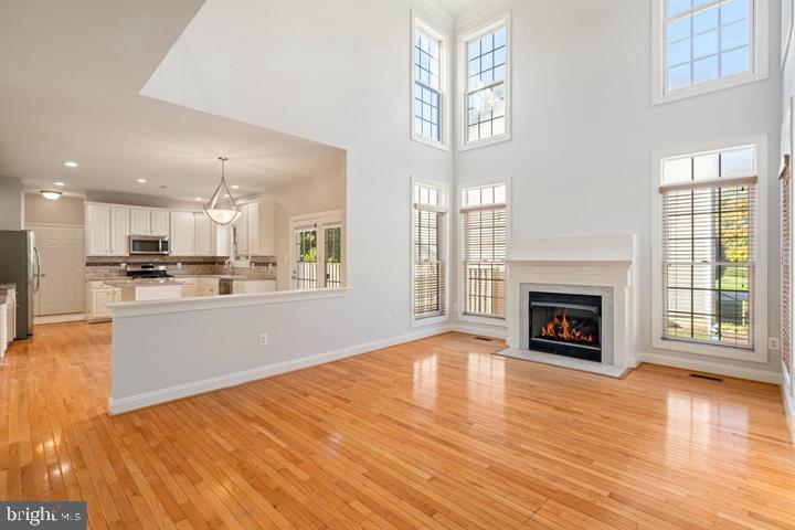 2038 Madrillon Road Vienna, VA 22182 - Photo 5 of 63 a open kitchen with granite countertop a stove top oven a sink dishwasher and a fireplace with wooden floor