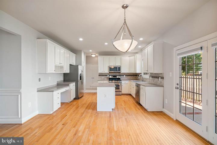 2038 Madrillon Road Vienna, VA 22182 - Photo 8 of 63 a large kitchen with kitchen island a large counter space a sink appliances and cabinets