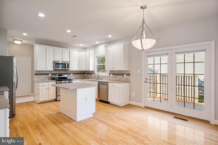 2038 Madrillon Road Vienna, VA 22182 - Photo 9 of 63 a kitchen with granite countertop white cabinets and stainless steel appliances