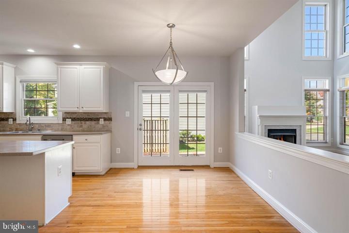 2038 Madrillon Road Vienna, VA 22182 - Photo 10 of 63 a kitchen with stainless steel appliances granite countertop a stove a sink and white cabinets with wooden floor