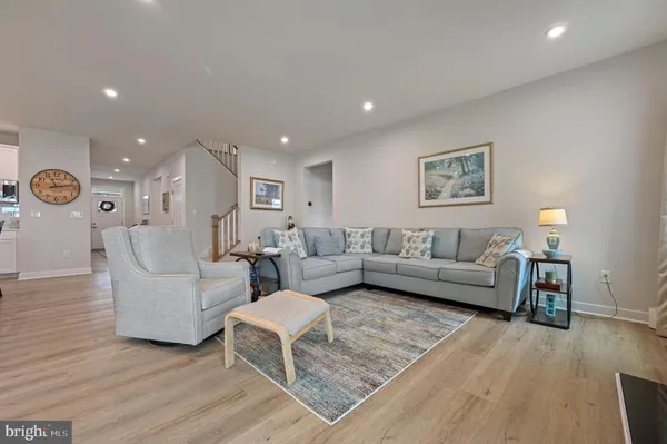 a living room with furniture and a dining table with kitchen view