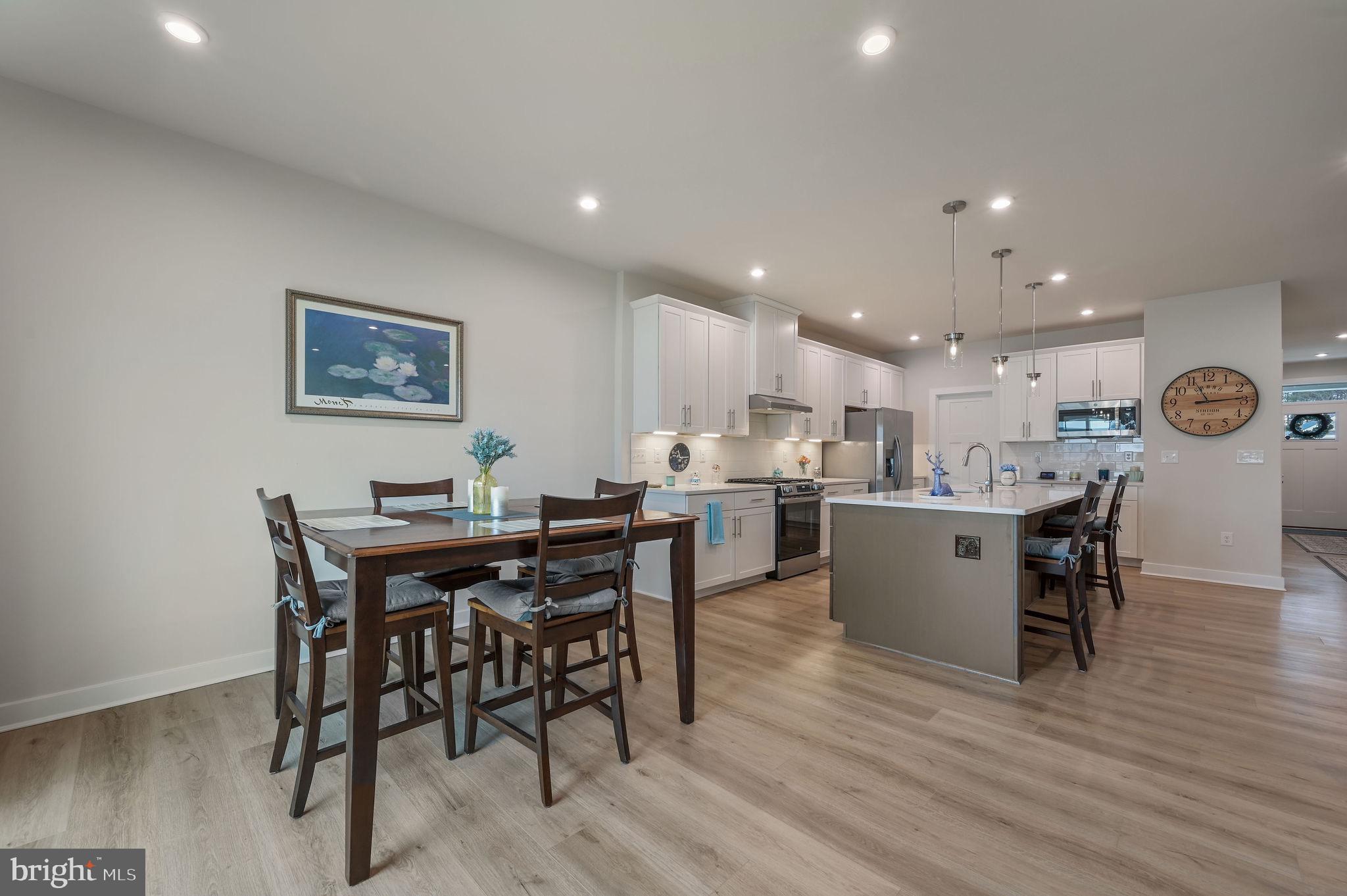 30366 Indigo Way Georgetown, DE 19947 - Photo 15 of 37 a living room with dining table and kitchen view with wooden floor