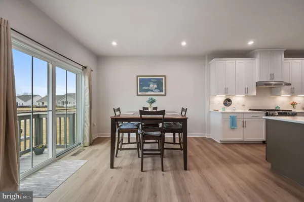 a view of a a dining room with furniture window and wooden floor
