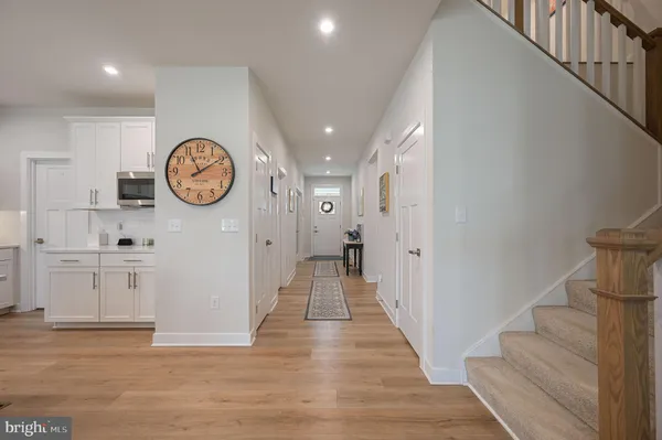 a kitchen with stainless steel appliances kitchen island granite countertop a table chairs sink and cabinets