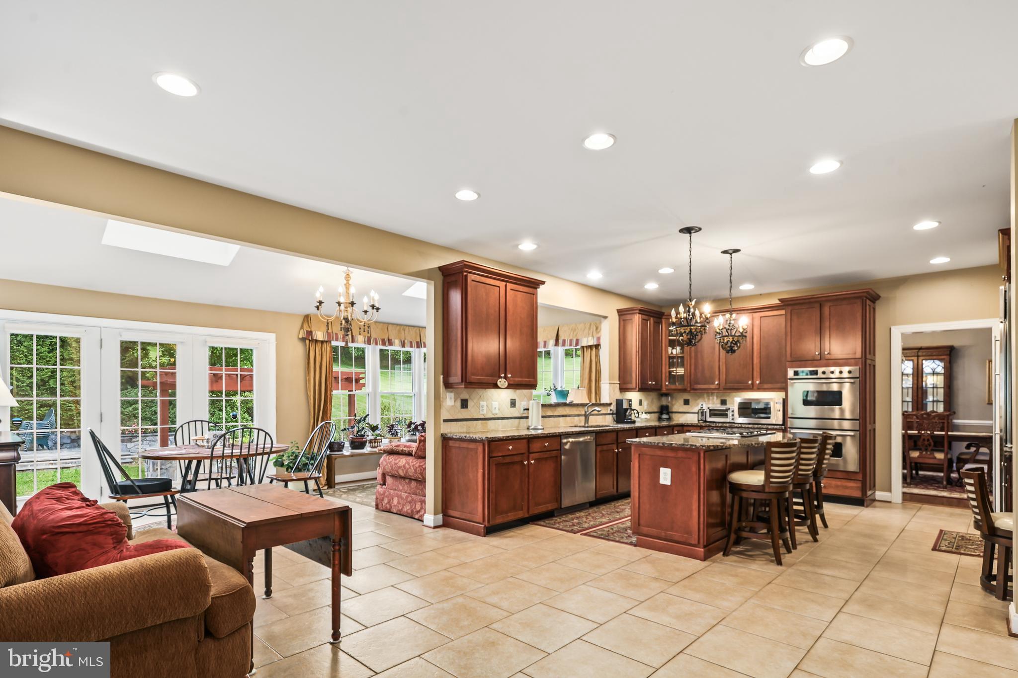 40890 Beechnut Road Leesburg, VA 20175 - Photo 18 of 65 a kitchen with stainless steel appliances kitchen island granite countertop a refrigerator and chairs