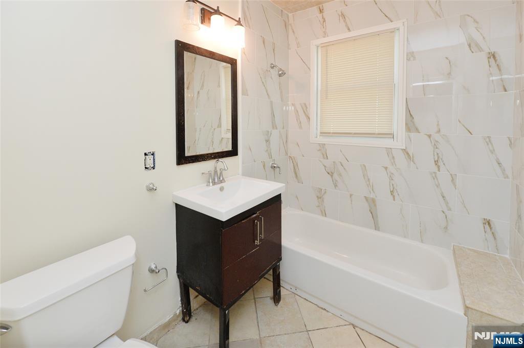 62 Broadway, Unit 1 Hackensack, NJ 07601 - Photo 7 of 25 a bathroom with a sink toilet and bathtub