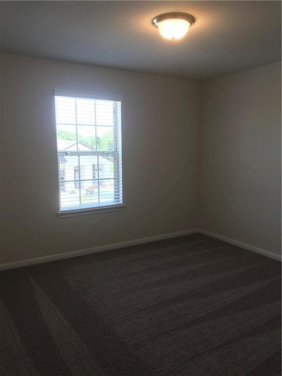 115 Iron Rail Road Dripping Springs, TX 78620 - Photo 11 of 16 Spare room featuring dark colored carpet and baseboards