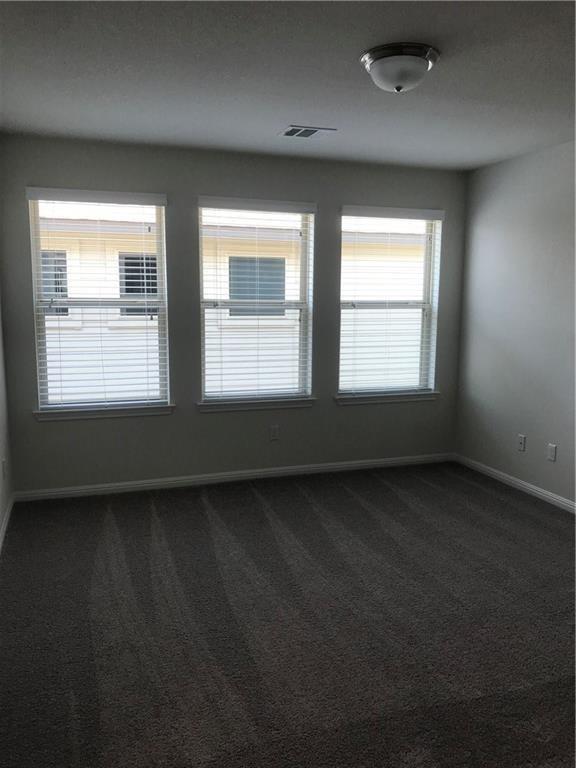 115 Iron Rail Road Dripping Springs, TX 78620 - Photo 14 of 16 Unfurnished room featuring dark colored carpet and baseboards