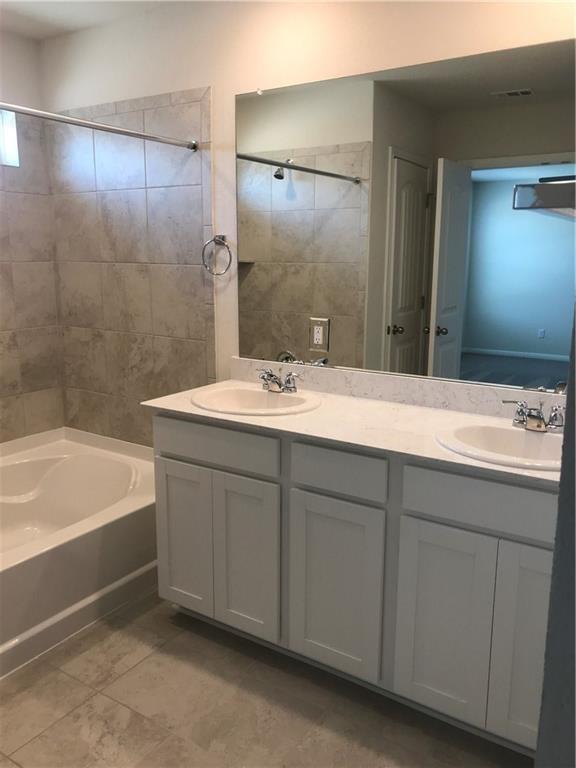 115 Iron Rail Road Dripping Springs, TX 78620 - Photo 8 of 16 Full bath featuring double vanity and tub / shower combination