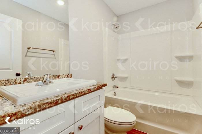 153 Cottage Grove Road Brunswick, GA 31525 - Photo 14 of 16 a bathroom with a granite countertop sink a toilet a mirror and shower