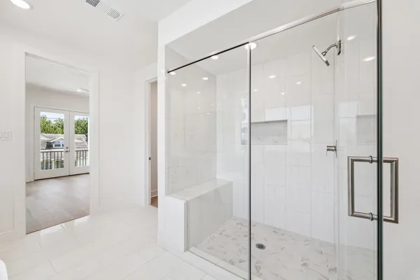 a bathroom with a shower and a glass door