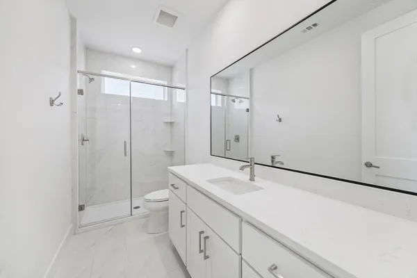 a bathroom with a sink a toilet and shower