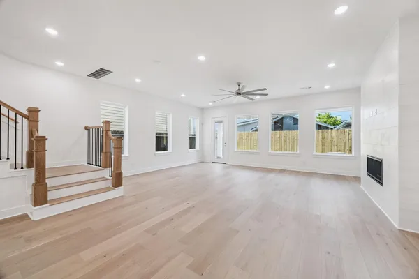 a view of an empty room with a window and fireplace