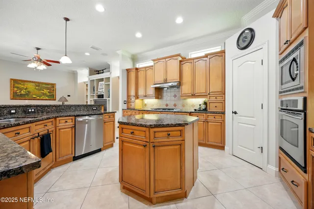 a kitchen with granite countertop stainless steel appliances a stove sink and microwave