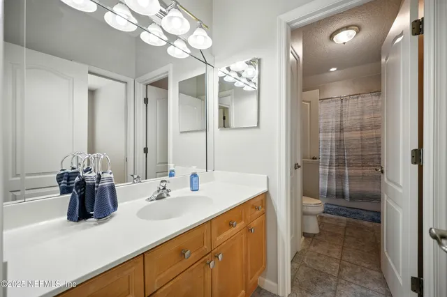 a view of an empty room with wooden floor and a bathroom