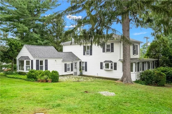 a front view of a house with a yard and trees