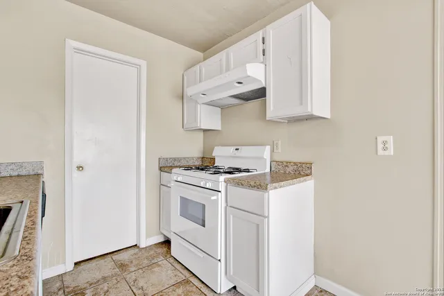 a kitchen with white cabinets and white appliances