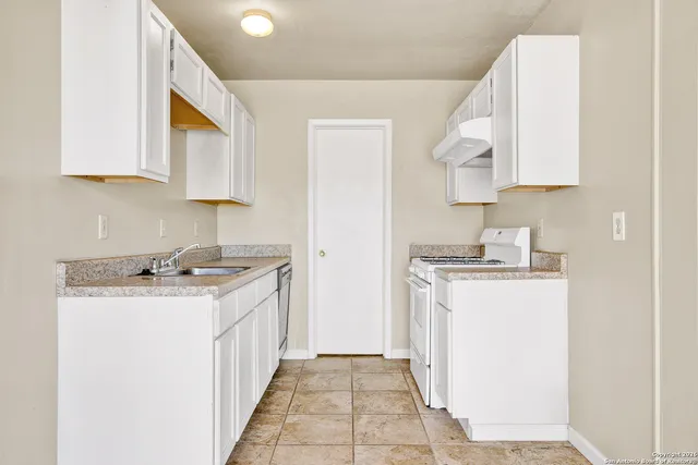 a kitchen with a sink stove and cabinets