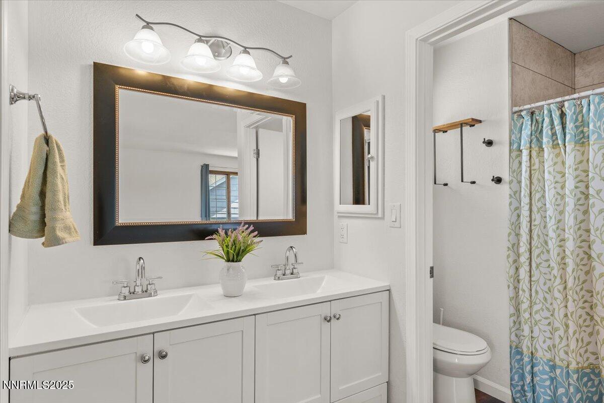 2060 Kings Row Reno, NV 89503 - Photo 24 of 37 a bathroom with a double vanity sink and mirror with toilet