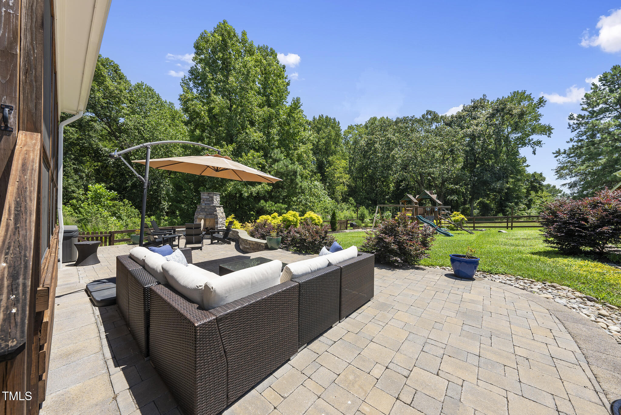 2416 Eddie Howard Road Willow Spring, NC 27592 - Photo 15 of 64 a view of a patio with a table and chairs under an umbrella