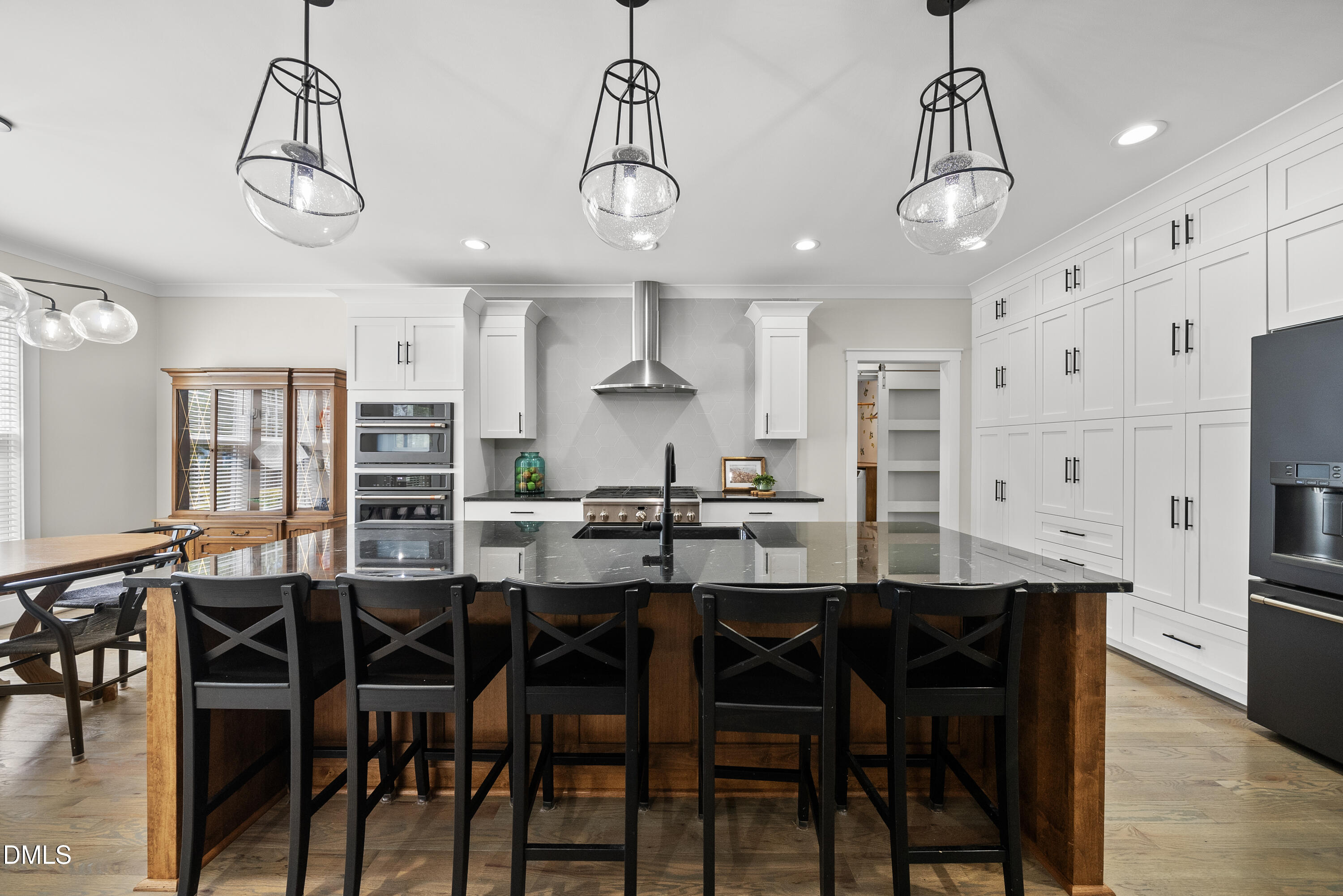 2416 Eddie Howard Road Willow Spring, NC 27592 - Photo 41 of 64 a kitchen with stainless steel appliances a dining table chairs and white cabinets